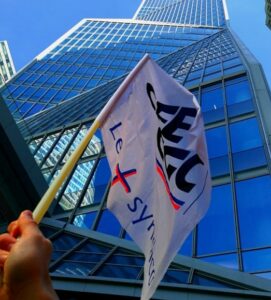 main brandissant le drapeau CFE-CGC devant le siège social de Thales